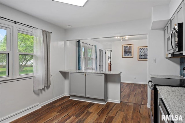 kitchen with electric range, light stone counters, baseboard heating, stainless steel microwave, and dark wood-type flooring