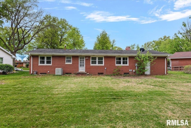 rear view of house featuring brick siding, crawl space, central AC unit, a chimney, and a yard
