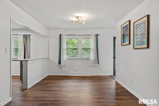 spare room featuring baseboards, a baseboard radiator, a notable chandelier, and dark wood-style floors