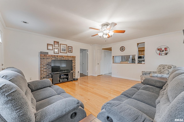 living area with a ceiling fan, baseboards, ornamental molding, and wood finished floors