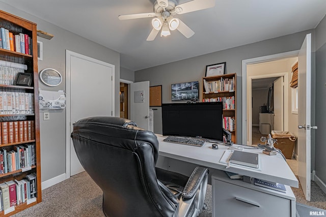office space with baseboards, ceiling fan, and carpet