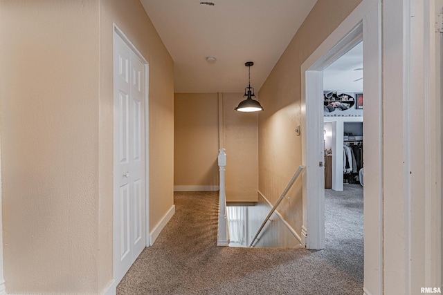 corridor with carpet floors and an upstairs landing