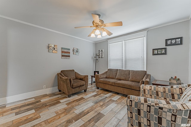 living area featuring crown molding, light wood-style flooring, ceiling fan, and baseboards