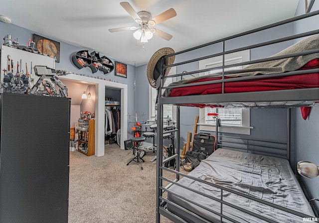 bedroom featuring carpet flooring, a ceiling fan, a walk in closet, and a closet