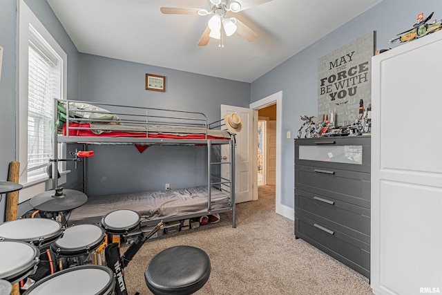 carpeted bedroom featuring multiple windows and ceiling fan