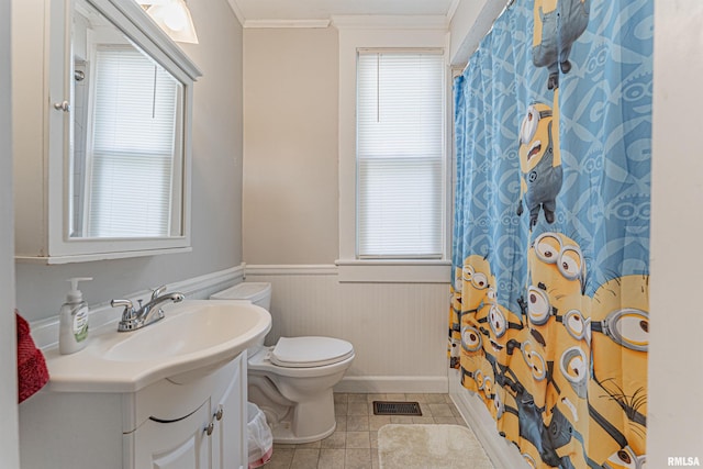 bathroom featuring tile patterned flooring, vanity, toilet, a wainscoted wall, and ornamental molding