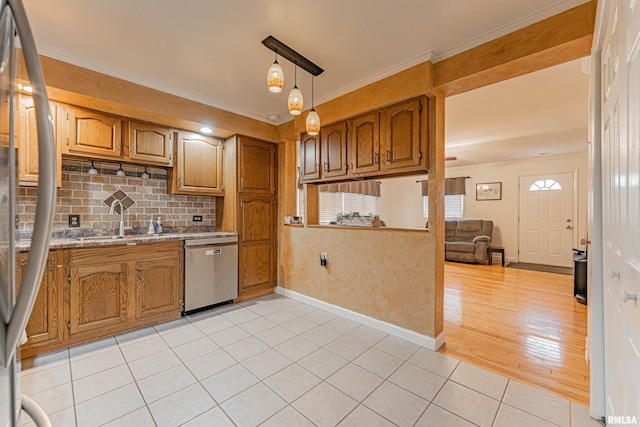 kitchen with brown cabinetry, a sink, dishwasher, and ornamental molding
