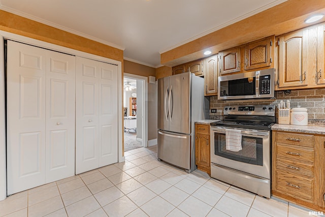 kitchen featuring crown molding, appliances with stainless steel finishes, backsplash, and light countertops