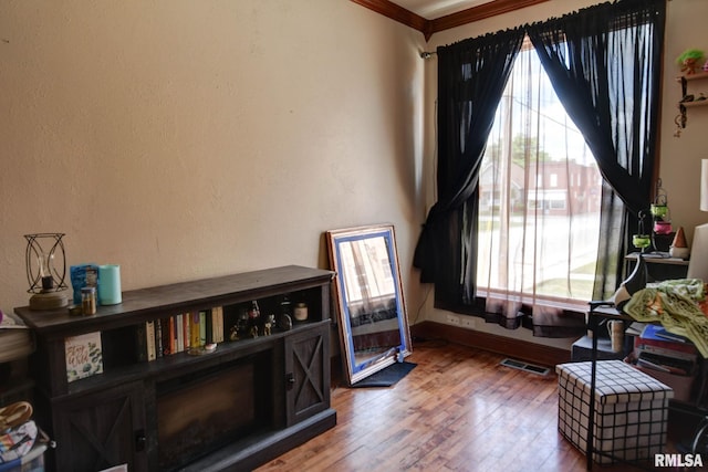 629 W Adams St, Taylorville, IL 62568 - living area with light wood-style flooring, baseboards, and crown molding