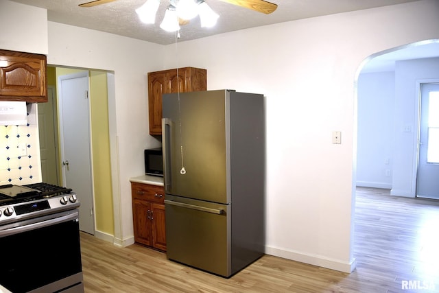 24 Parkway Dr, Sherman, IL 62684 - kitchen with appliances with stainless steel finishes, arched walkways, a ceiling fan, and light wood-style flooring