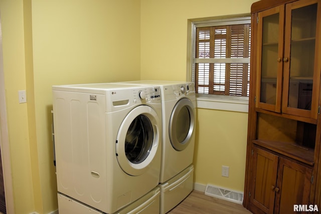 24 Parkway Dr, Sherman, IL 62684 - washroom featuring separate washer and dryer, cabinet space, baseboards, and light wood-type flooring