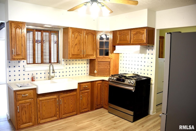 24 Parkway Dr, Sherman, IL 62684 - kitchen with under cabinet range hood, stainless steel appliances, a sink, brown cabinets, and ceiling fan