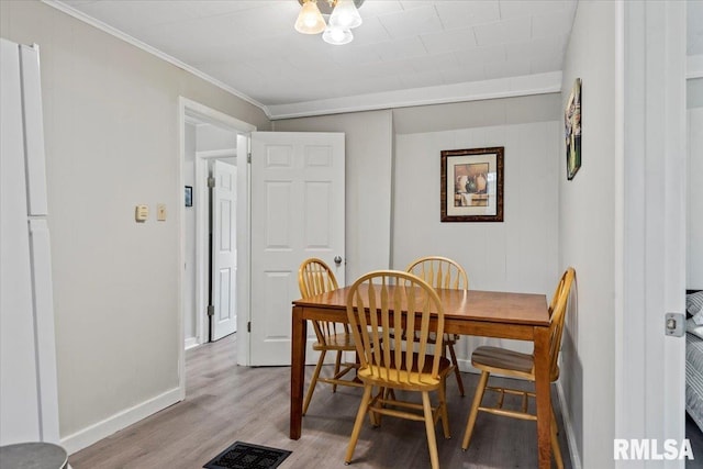 1127 N 6th St, Springfield, IL 62702 - dining area with crown molding, baseboards, light wood-style flooring, and visible vents