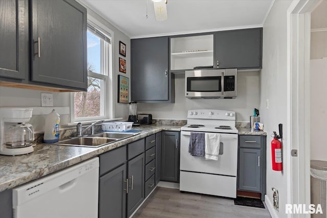 1127 N 6th St, Springfield, IL 62702 - kitchen with open shelves, wood finished floors, white appliances, a sink, and a wealth of natural light
