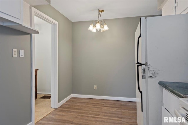 1127 N 6th St, Springfield, IL 62702 - unfurnished dining area with a chandelier and light wood-style floors