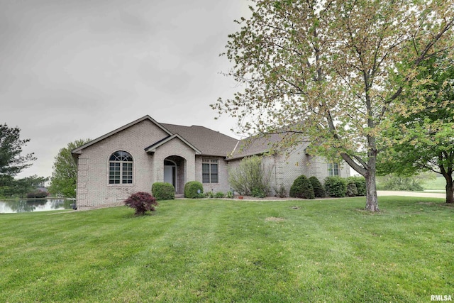 3408 Wynvalley Rd, Quincy, IL 62301 - view of front of home with brick siding, a front lawn, a water view, and a shingled roof