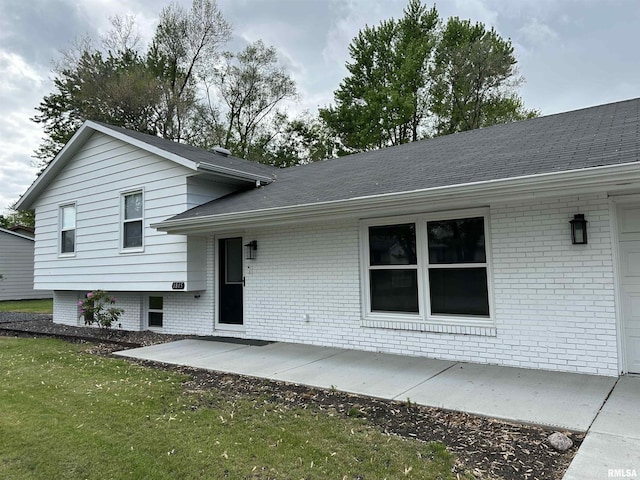 1815 Stonehenge Rd, Springfield, IL 62702 - rear view of property with brick siding, roof with shingles, and a lawn