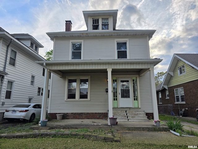 traditional style home with covered porch and a chimney