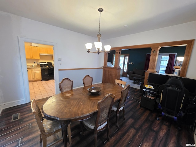 dining area featuring visible vents, wood finished floors, and a notable chandelier