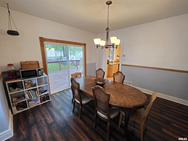 dining room featuring visible vents, wood finished floors, and a chandelier