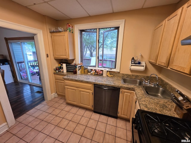 kitchen featuring a paneled ceiling, light tile patterned floors, black appliances, and a wealth of natural light