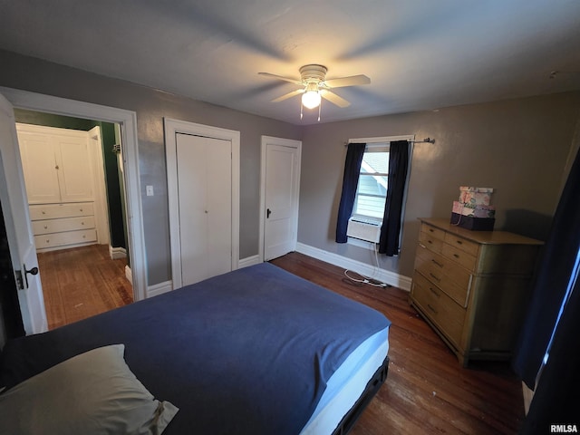 bedroom featuring two closets, dark wood-style flooring, baseboards, and ceiling fan