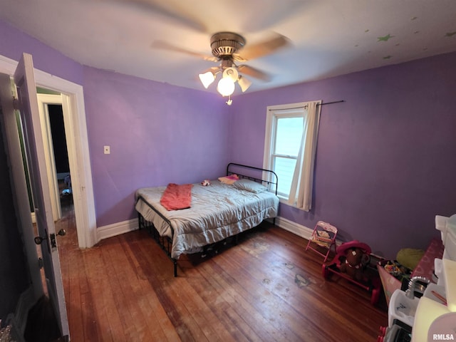 bedroom featuring baseboards, a ceiling fan, and hardwood / wood-style floors