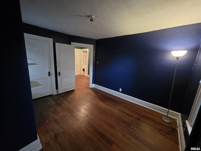 unfurnished bedroom featuring baseboards and wood finished floors