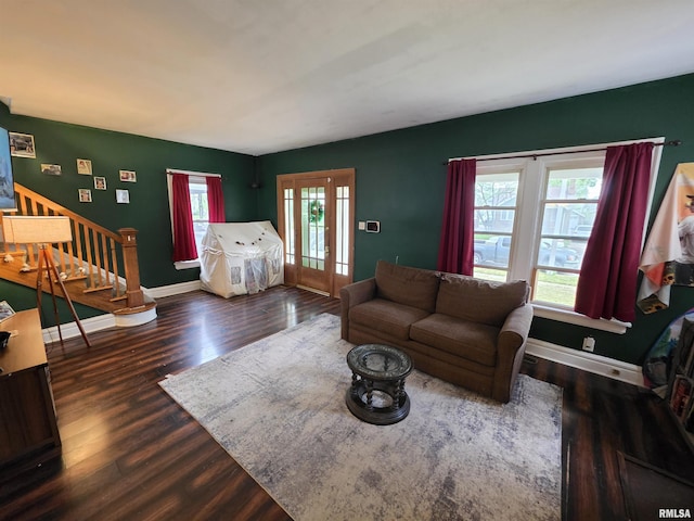 living area with baseboards, french doors, wood finished floors, and stairway