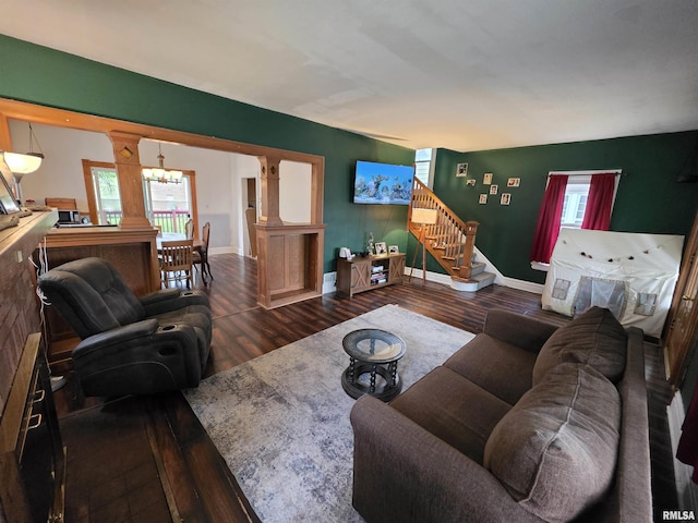 living room featuring baseboards, stairs, wood finished floors, and a chandelier