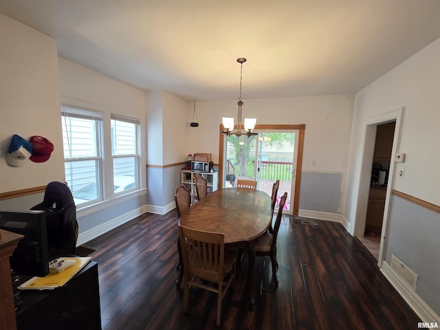 dining room with an inviting chandelier, a healthy amount of sunlight, and dark wood-type flooring