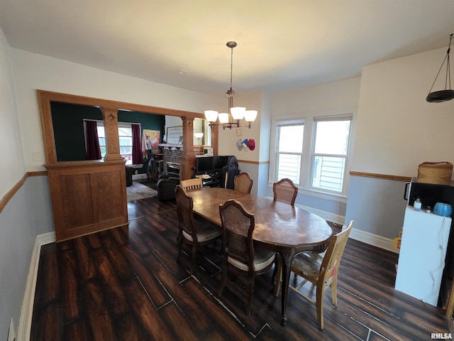 dining area with baseboards, decorative columns, a chandelier, and dark wood-style floors
