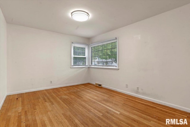 empty room with baseboards, light wood-style flooring, and visible vents