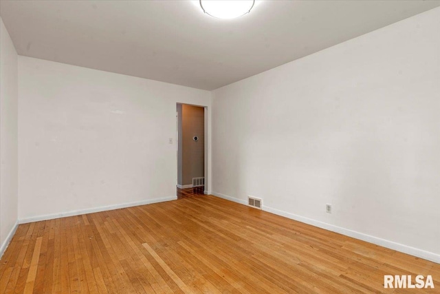 empty room featuring baseboards, light wood-style floors, and visible vents