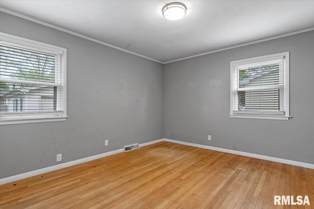 unfurnished room featuring crown molding, light wood finished floors, and plenty of natural light