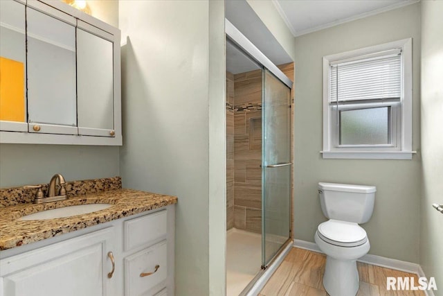 bathroom featuring crown molding, vanity, toilet, baseboards, and a stall shower