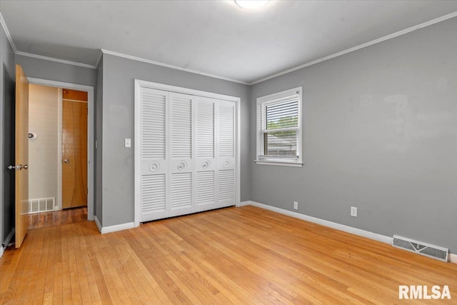 unfurnished bedroom with a closet, light wood-type flooring, and visible vents