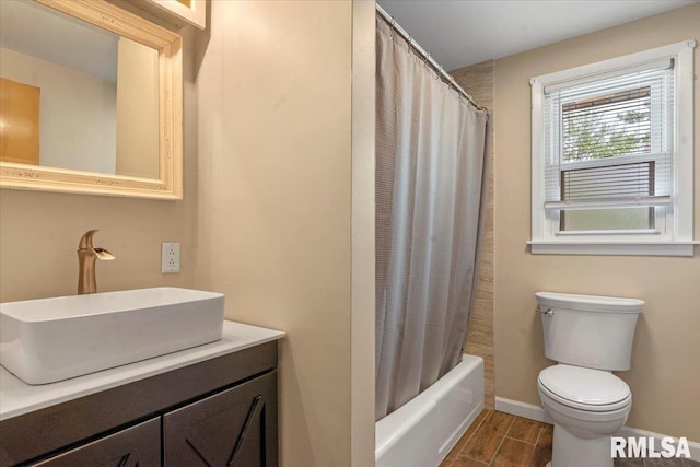 full bathroom with wood finished floors, shower / tub combo, vanity, baseboards, and toilet