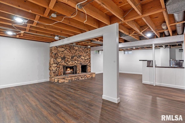 finished below grade area with baseboards, a fireplace, and wood finished floors