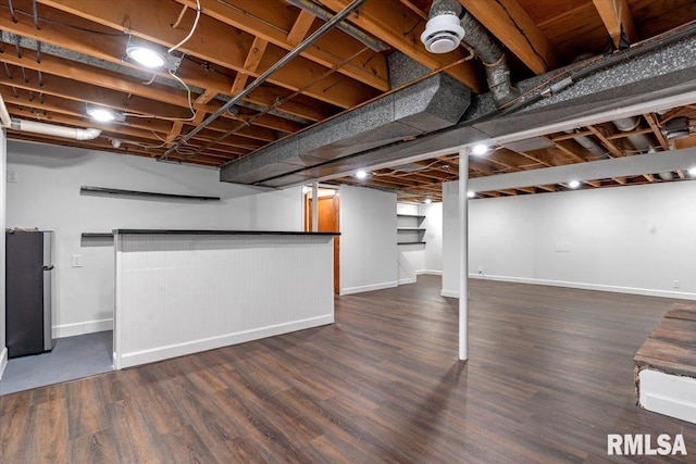 finished below grade area with freestanding refrigerator, baseboards, and wood finished floors