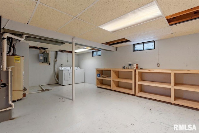 basement featuring water heater, separate washer and dryer, electric panel, and a paneled ceiling