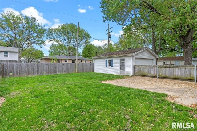 view of yard featuring a detached garage, an outbuilding, and a fenced backyard