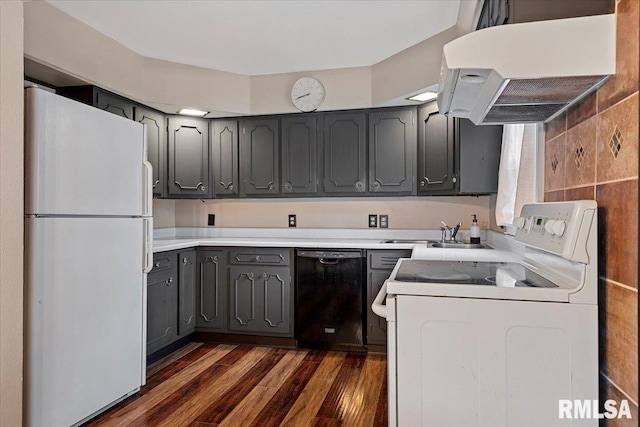 kitchen with exhaust hood, gray cabinetry, light countertops, dark wood-style floors, and white appliances