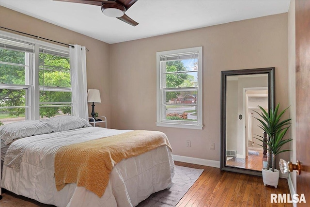 bedroom featuring a ceiling fan, baseboards, and hardwood / wood-style flooring
