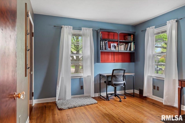 home office with baseboards, a healthy amount of sunlight, and hardwood / wood-style floors