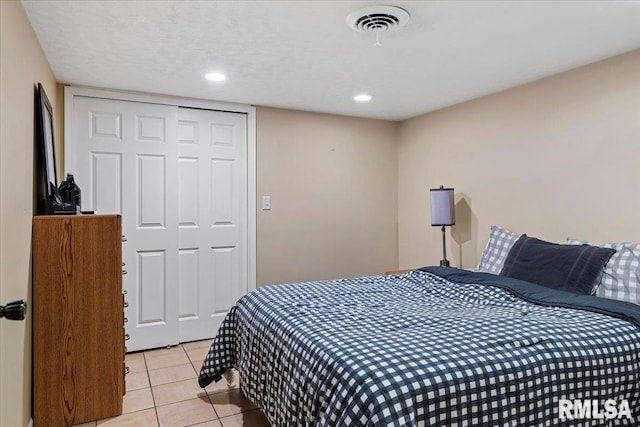 bedroom with visible vents, recessed lighting, light tile patterned floors, and a closet