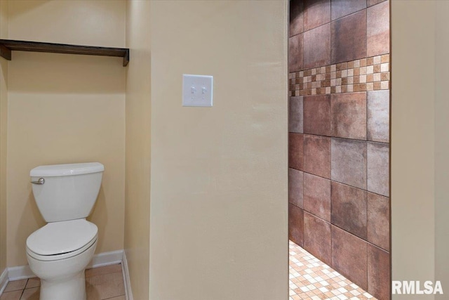 bathroom with baseboards, tile patterned floors, a tile shower, and toilet
