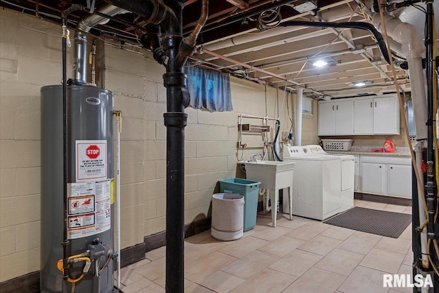 laundry room featuring separate washer and dryer, cabinet space, water heater, and concrete block wall