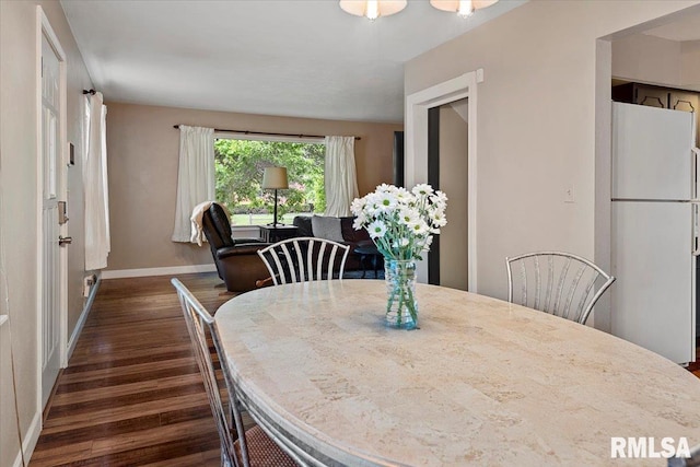 dining room featuring baseboards and dark wood-style floors