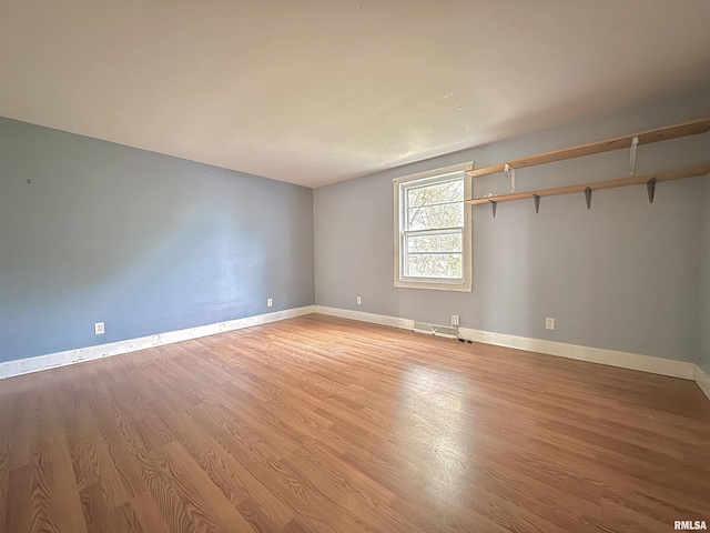 spare room with baseboards, light wood-style flooring, and visible vents
